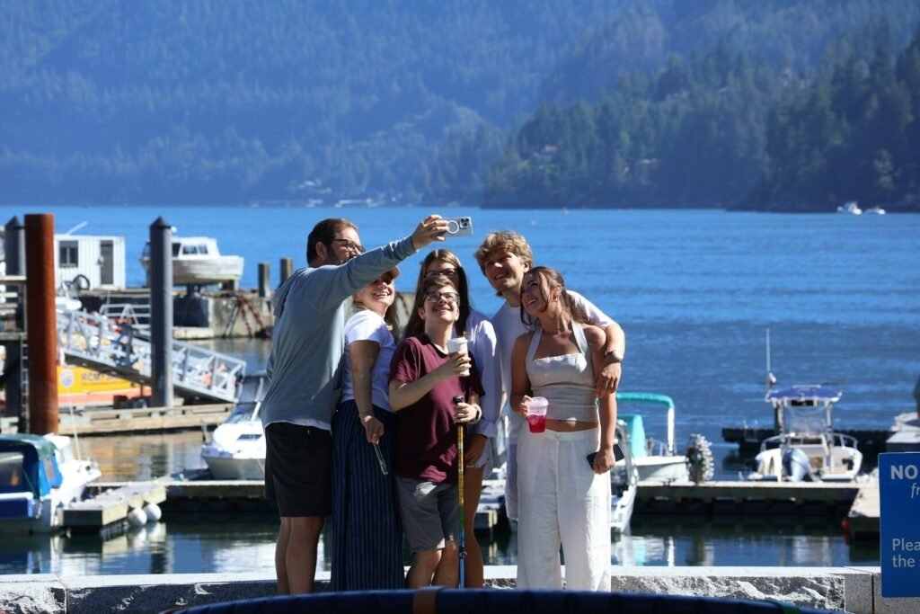 A family takes a selfie by the water.